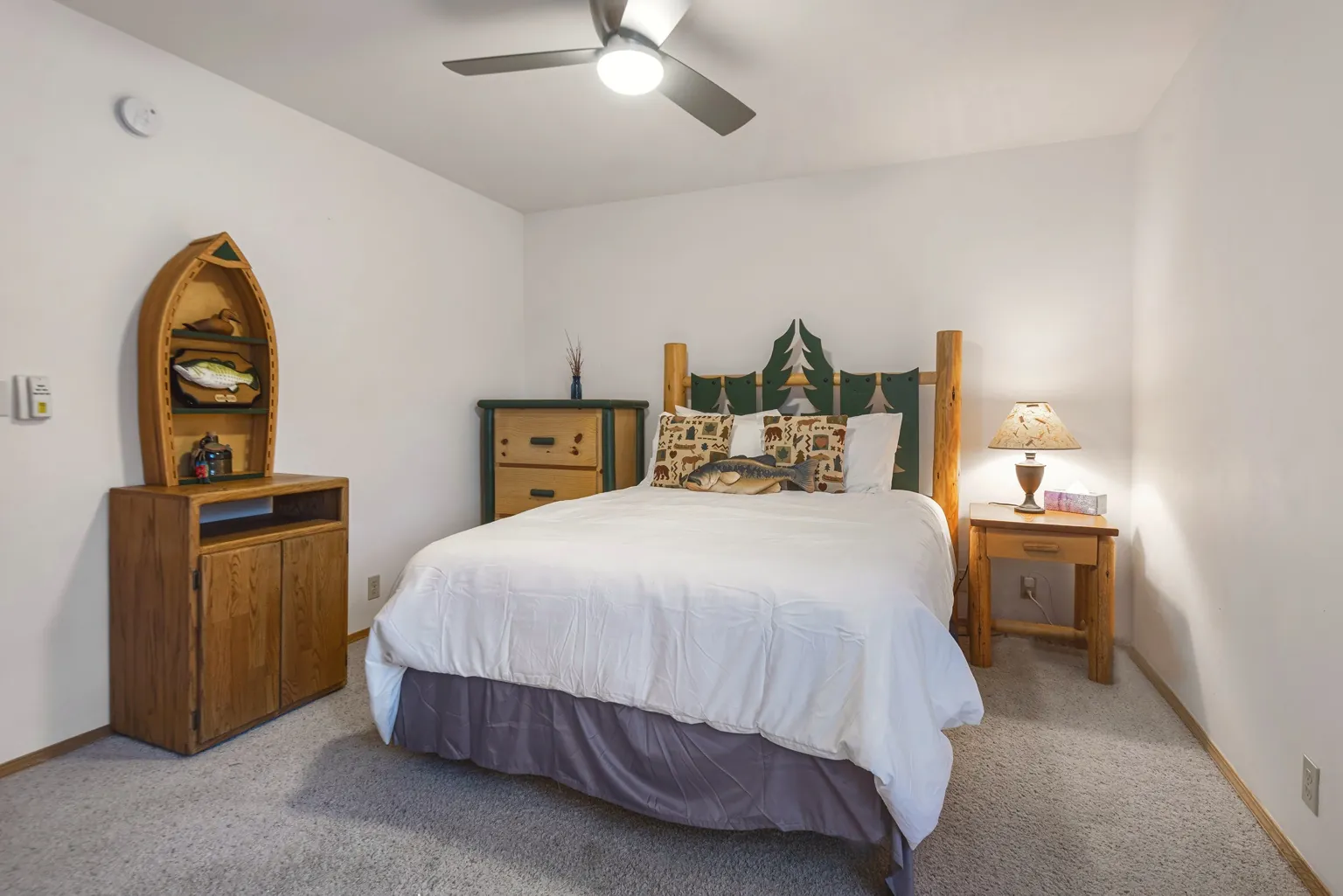 The Pendleton Room: lodge-style bed with white bedding and a ceiling fan