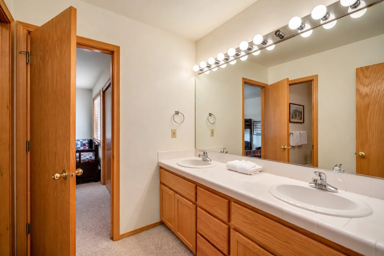 Second Jack-and-Jill bath with a double vanity and a door to a bunk room